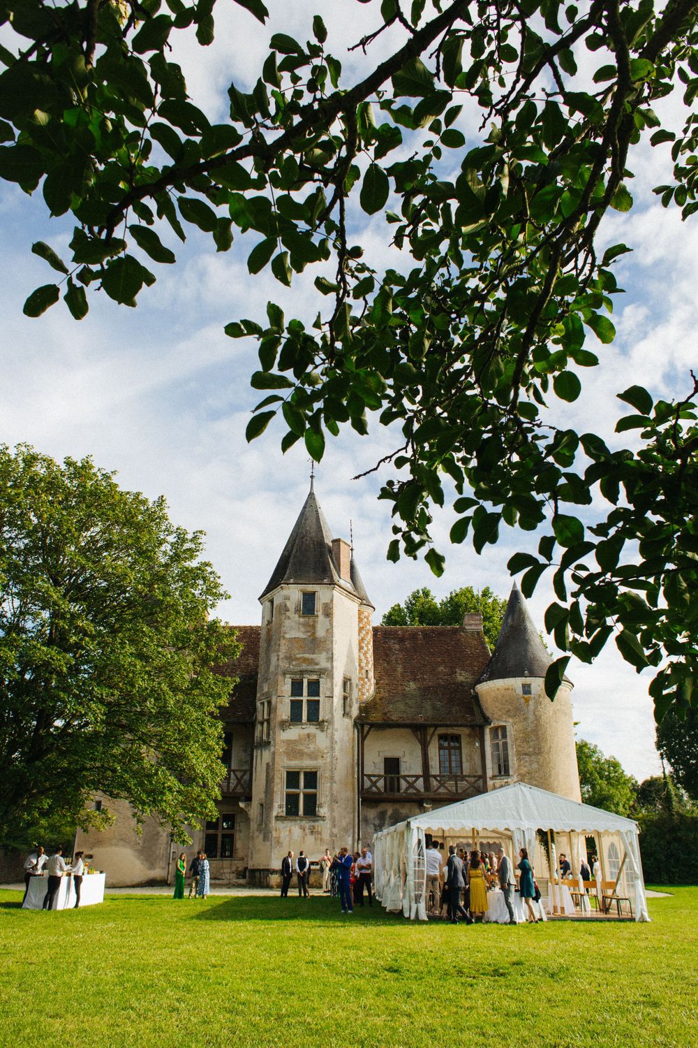 Elegant chateau wedding venue with white tent setup on a sunny day.