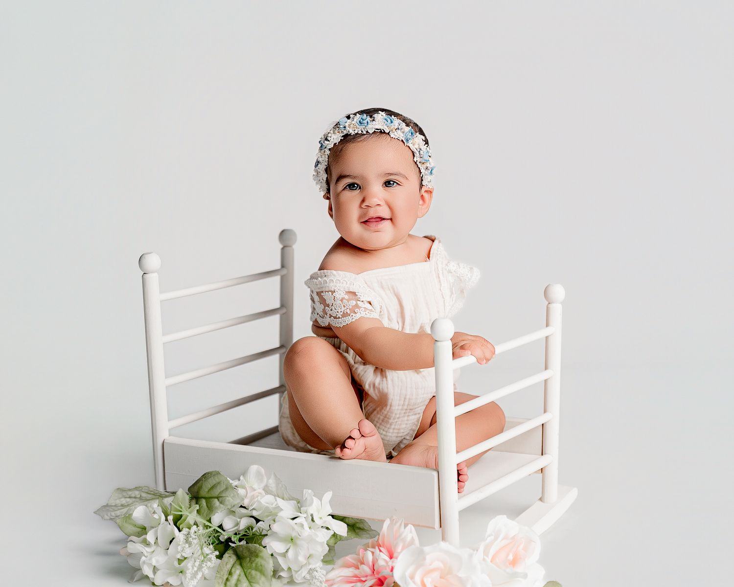 Sweet baby lying on soft blanket during professional photo shoot.