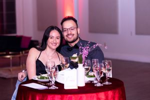 Couple enjoying dinner together at intimate table with wine glasses and formal place settings.