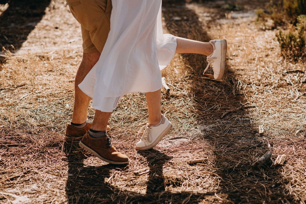 Close-up of contrasting boots and shoes on a rustic ground.