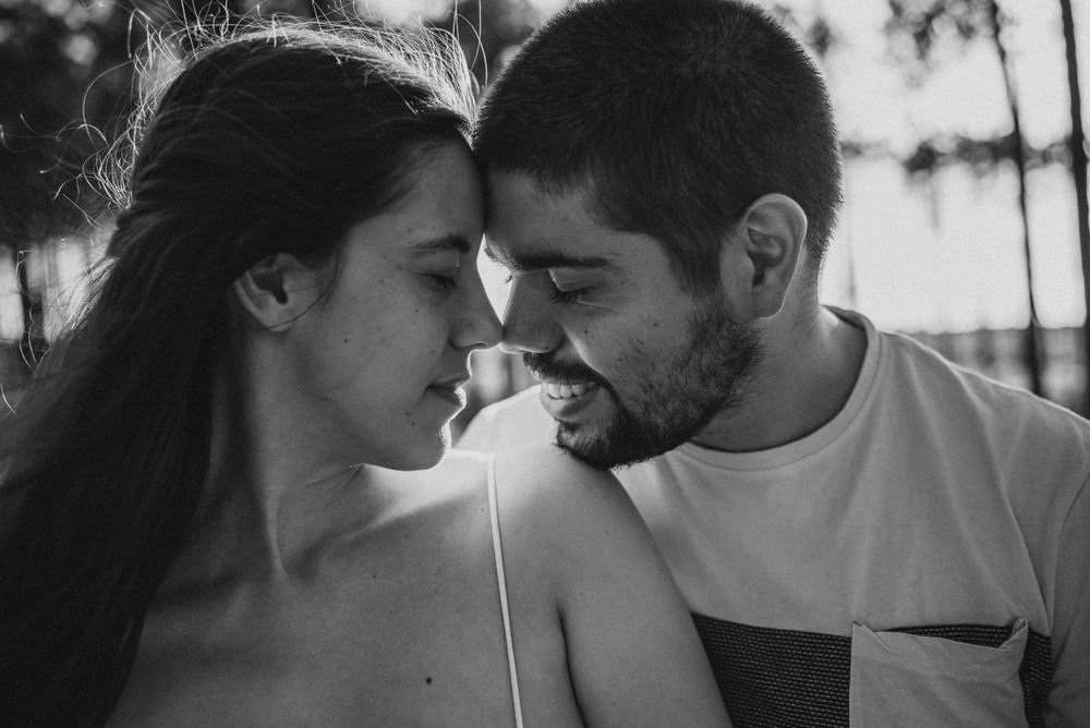 Intimate black and white portrait of a couple sharing a tender moment.