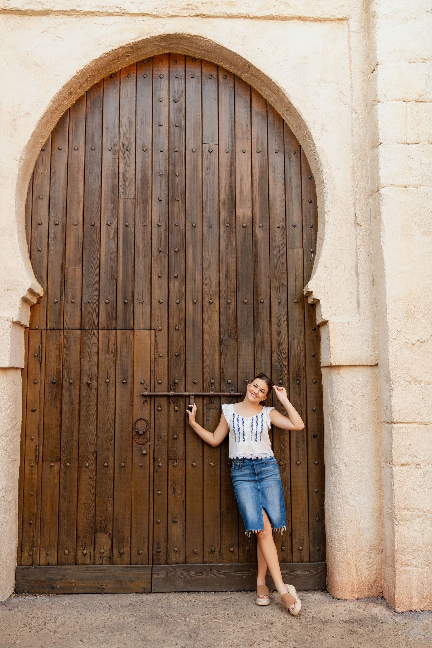 Outdoor portrait in front of building with pink architectural details.