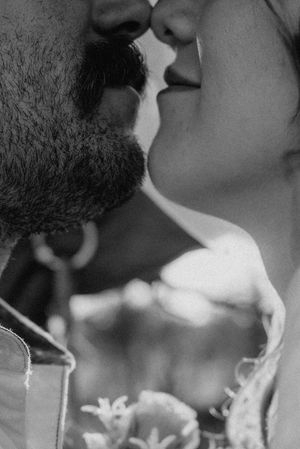 Black and white close-up photo of a bearded man and woman sharing a romantic kiss.