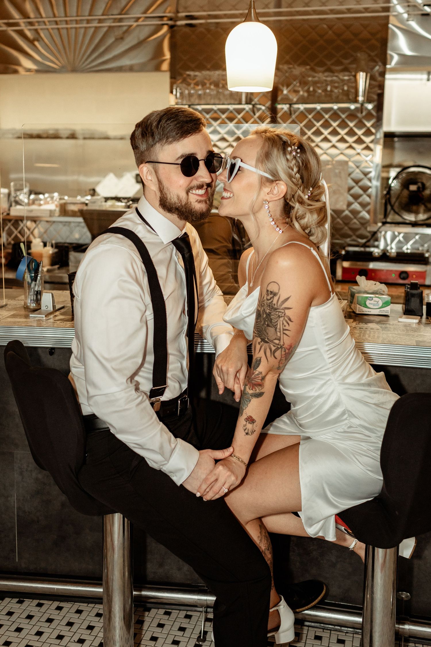 A stylish couple sharing an intimate moment at a retro-style diner bar.