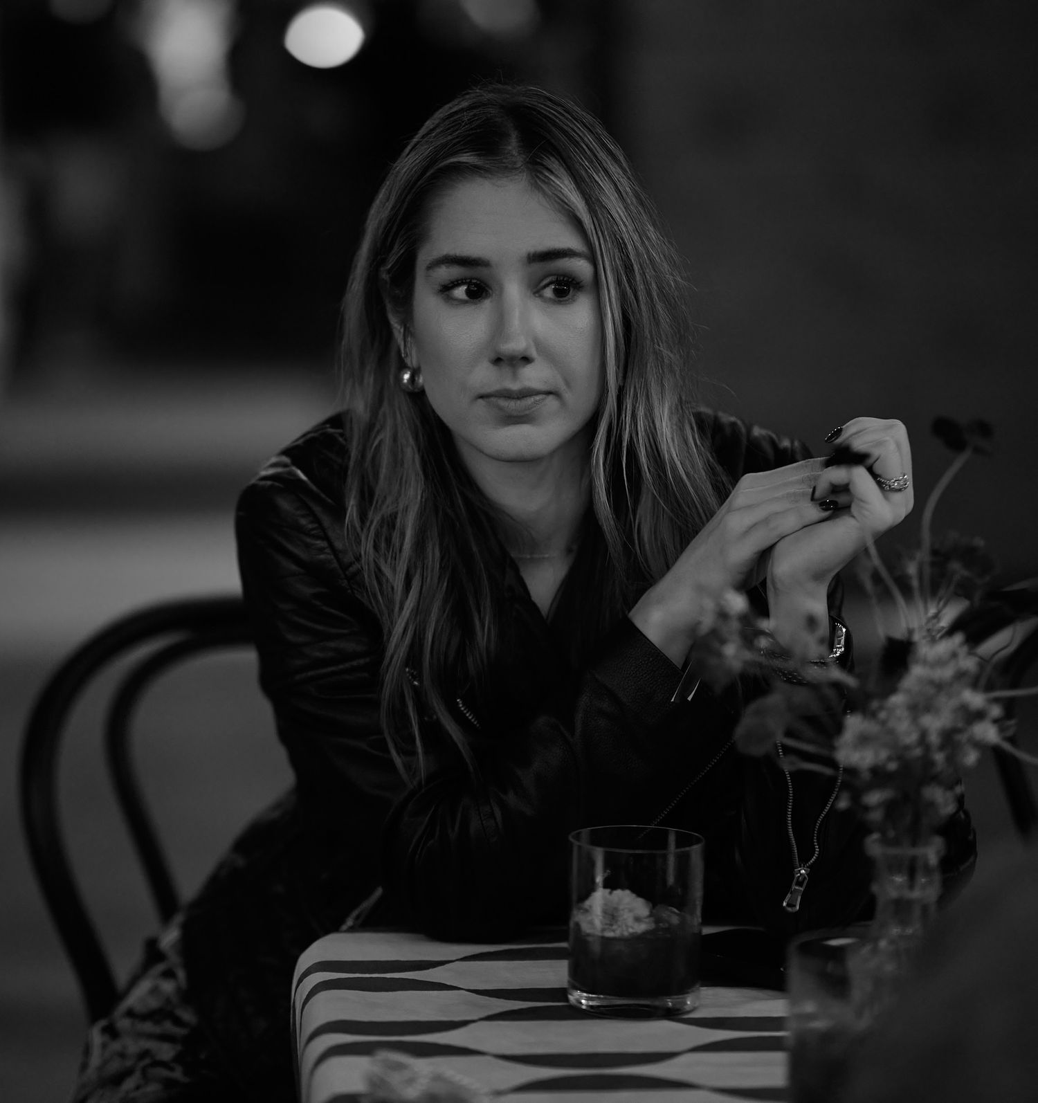 black and white portrait of Lauren of Zillow seated at a table with flowers engaging in conversation