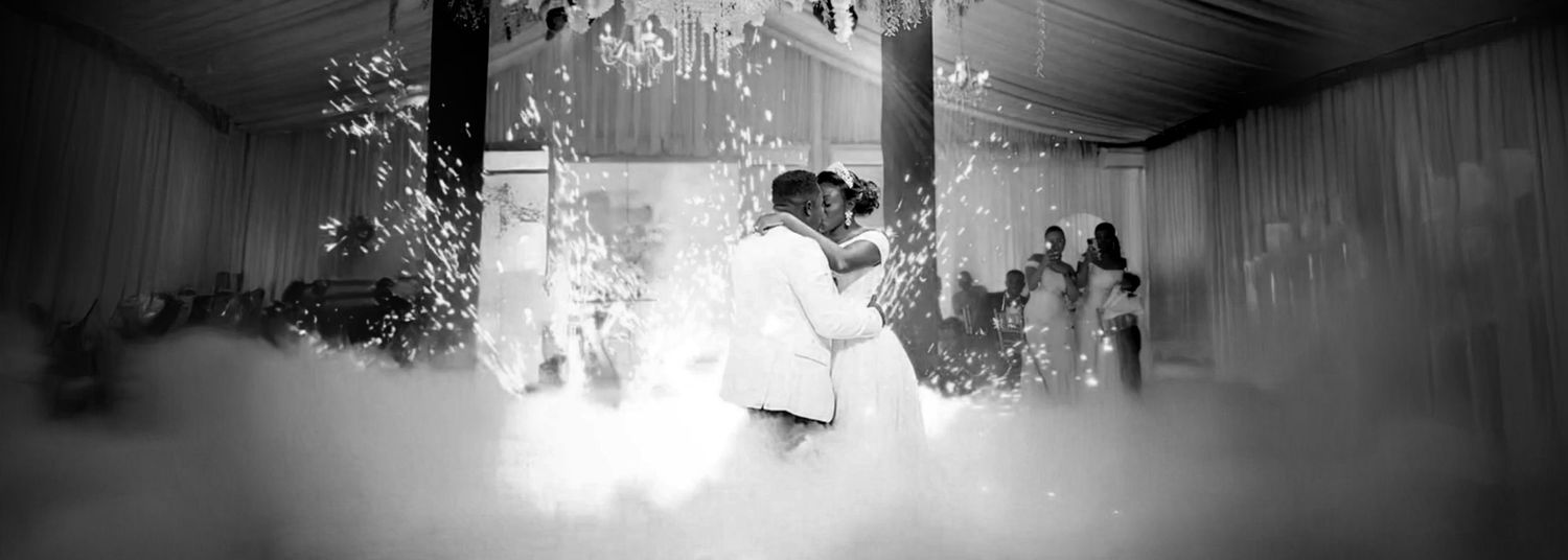 A romantic first dance captured in black and white with fog effects on the dance floor.