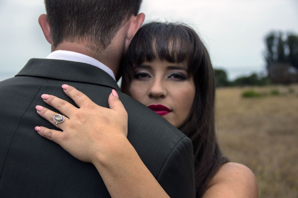 Close-up wedding portrait showing loving embrace against natural backdrop.