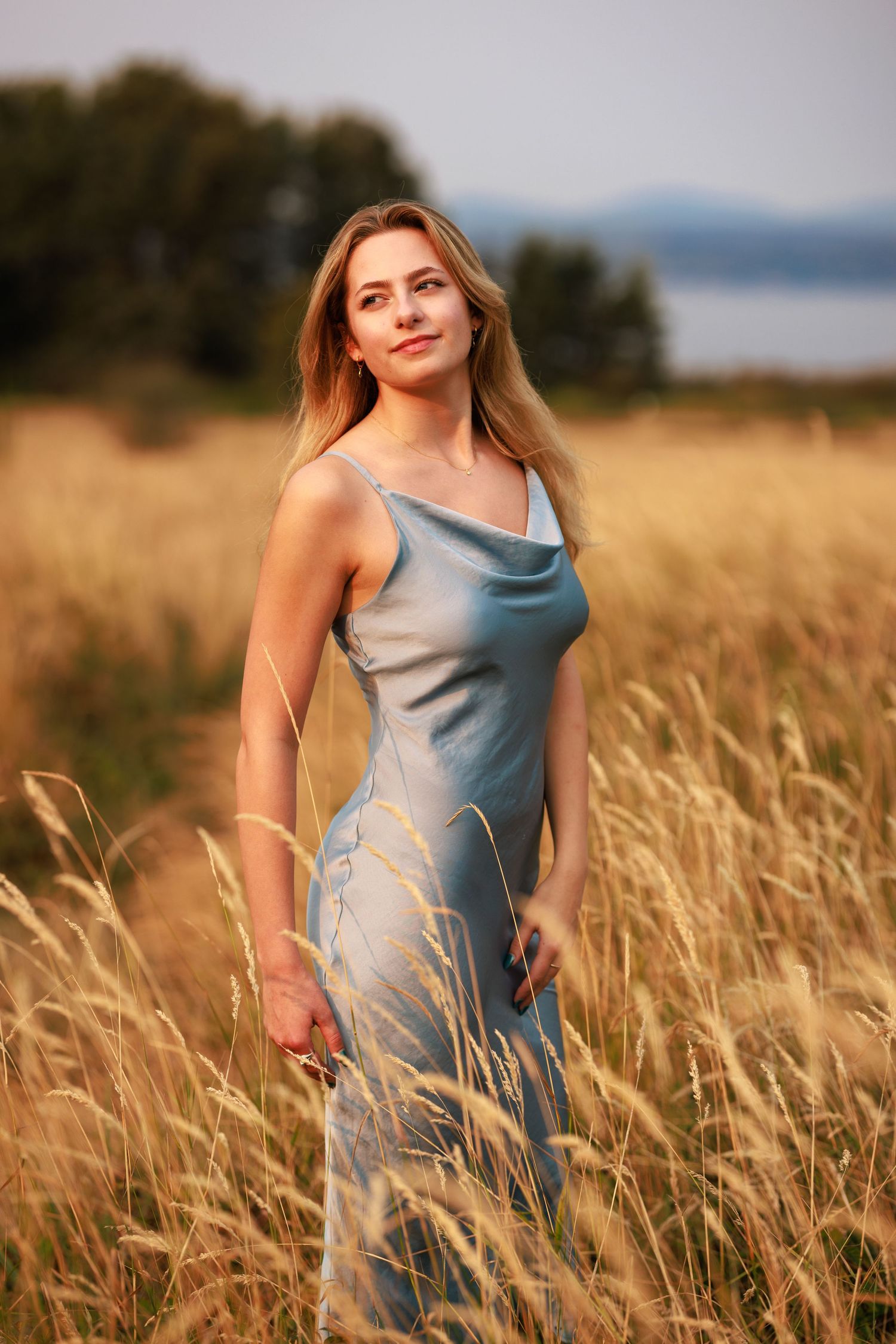 Portrait in golden grass field at sunrise.