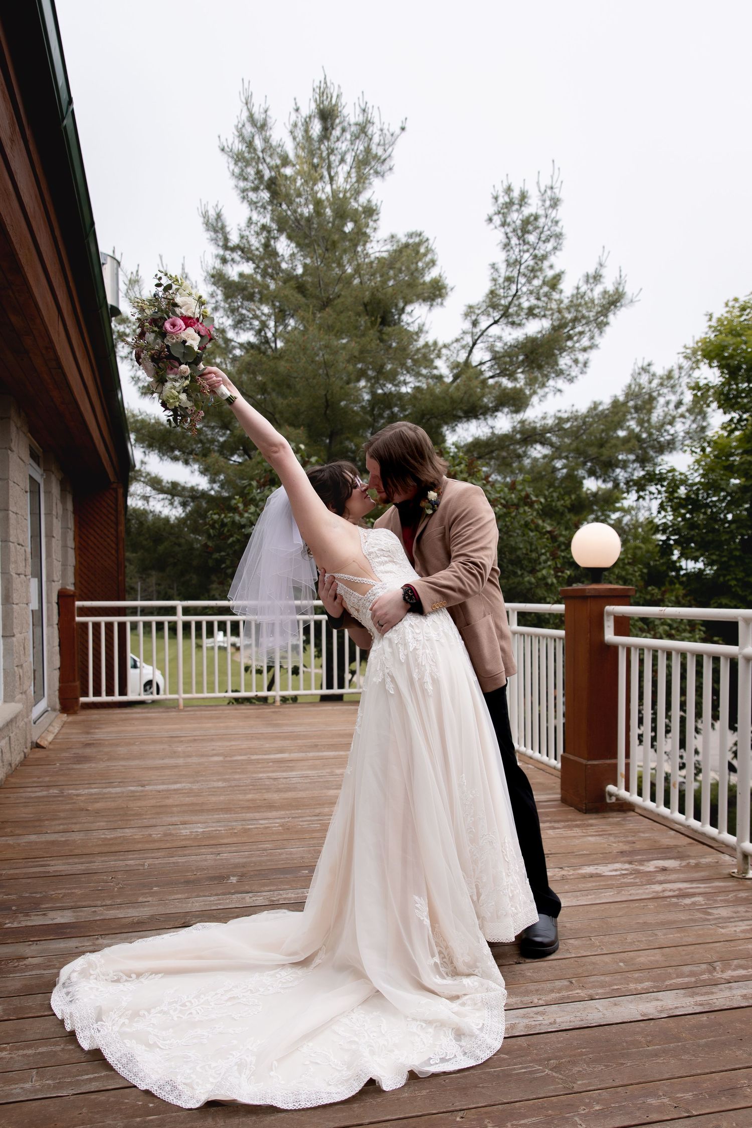 A romantic dance on a wooden deck with pine trees in the background.