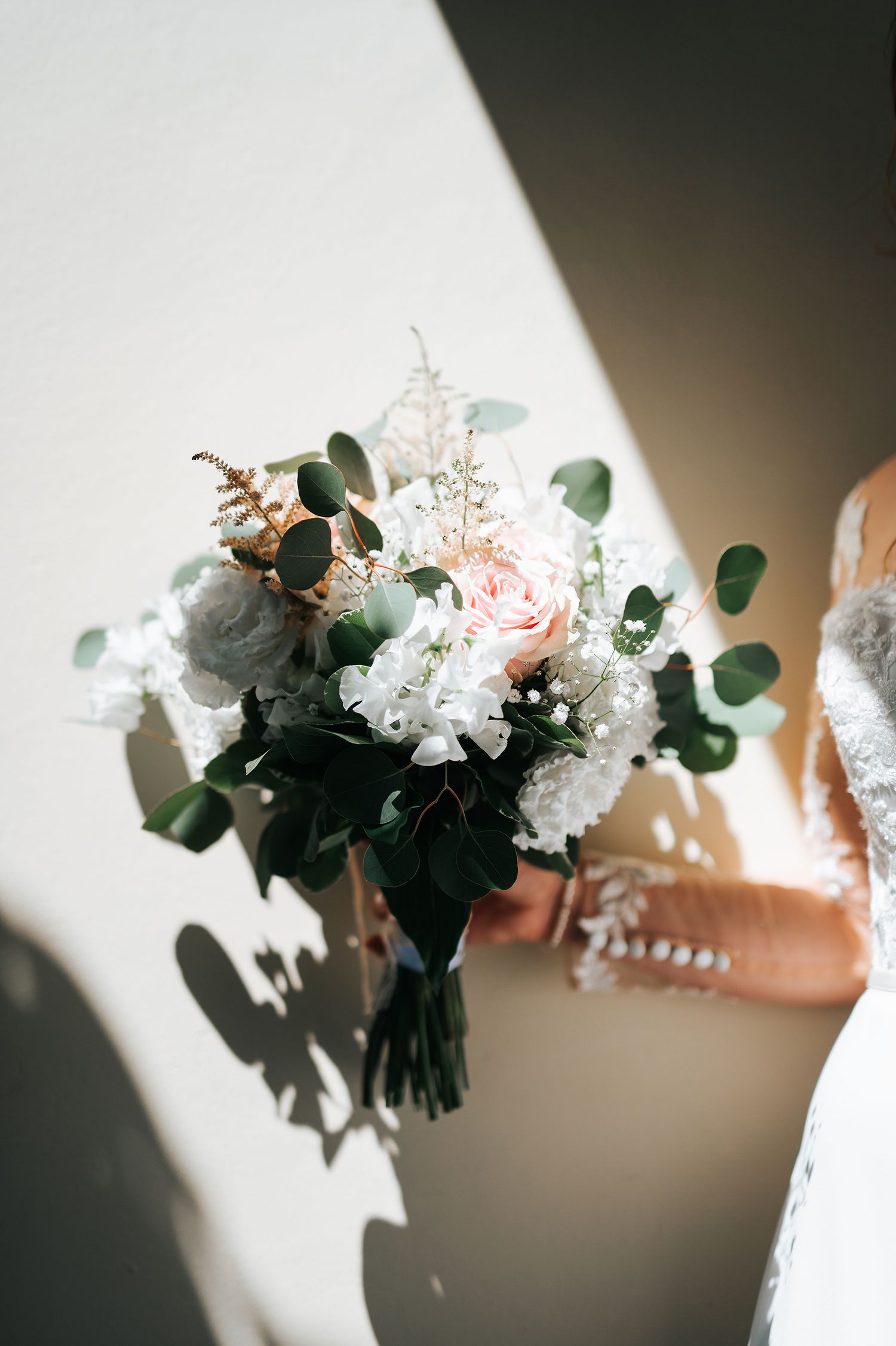 Elegant bridal bouquet with white hydrangeas, pink roses, and eucalyptus greenery.