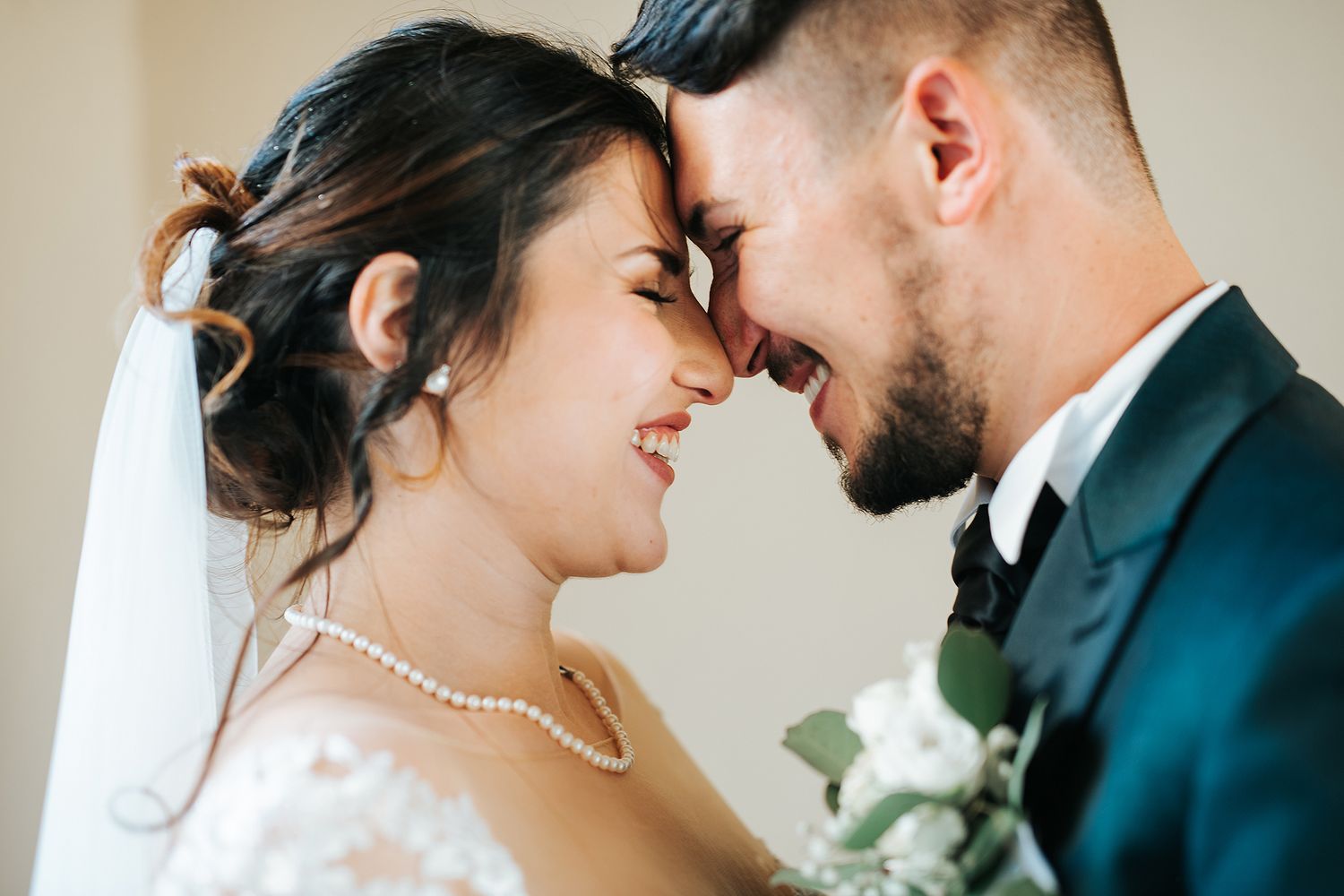 Bride and groom share an intimate forehead-to-forehead moment on their wedding day.