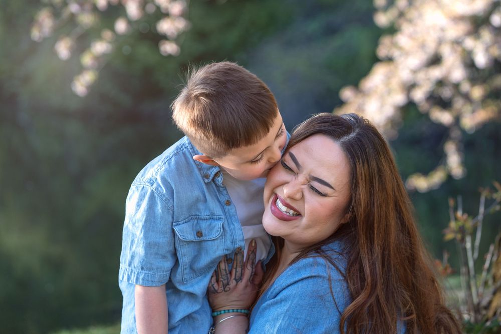 Sweet candid moment between parent and child laughing together outdoors.