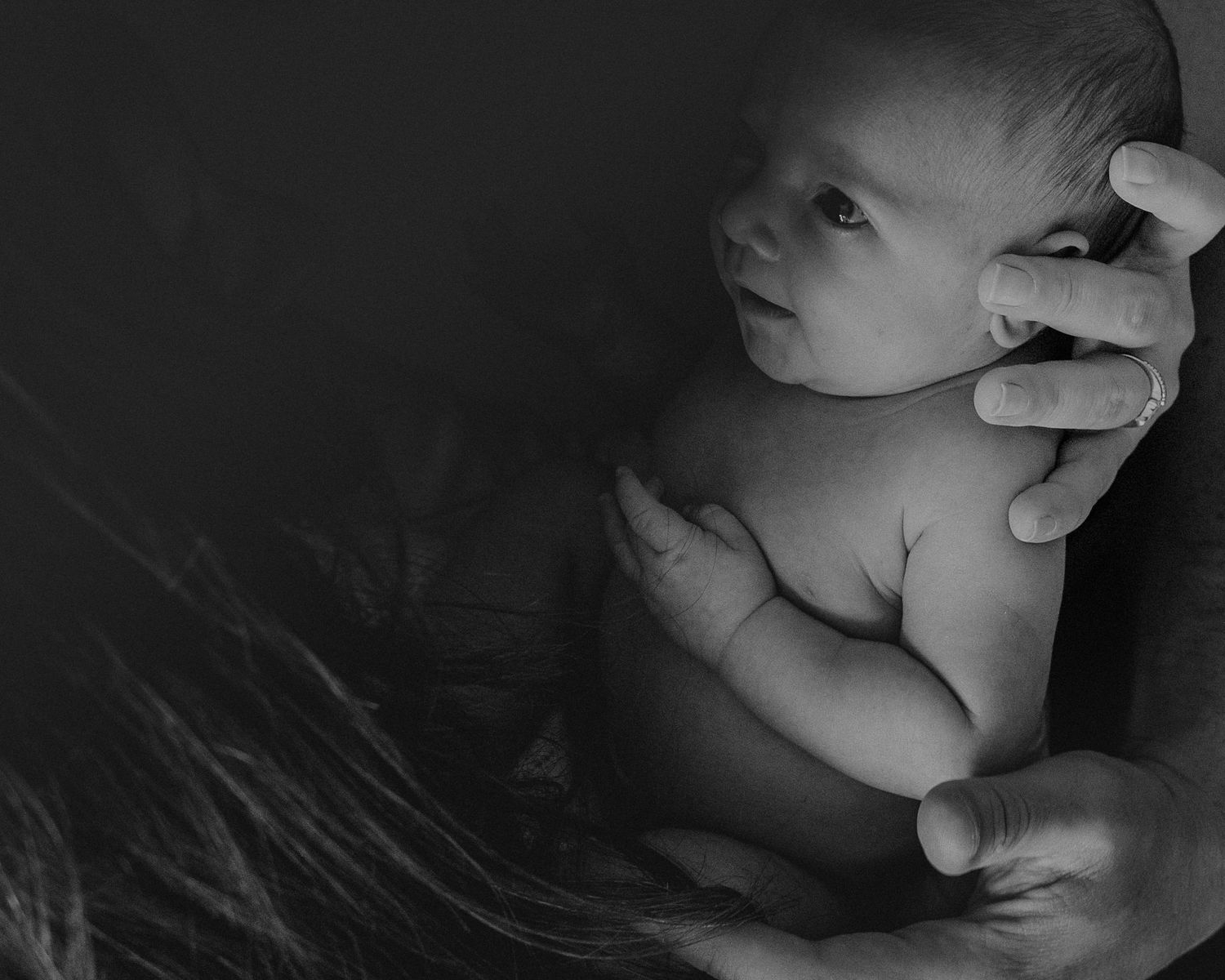 bebé recém nascido no colo da mãe foto em preto e branco com luz dura em fotografia família Caldas Da Rainha