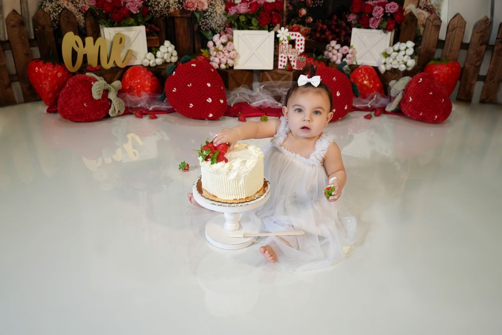 Rustic holiday scene with presents, decorative cakes, red bows, and white decor arranged in a festive display.