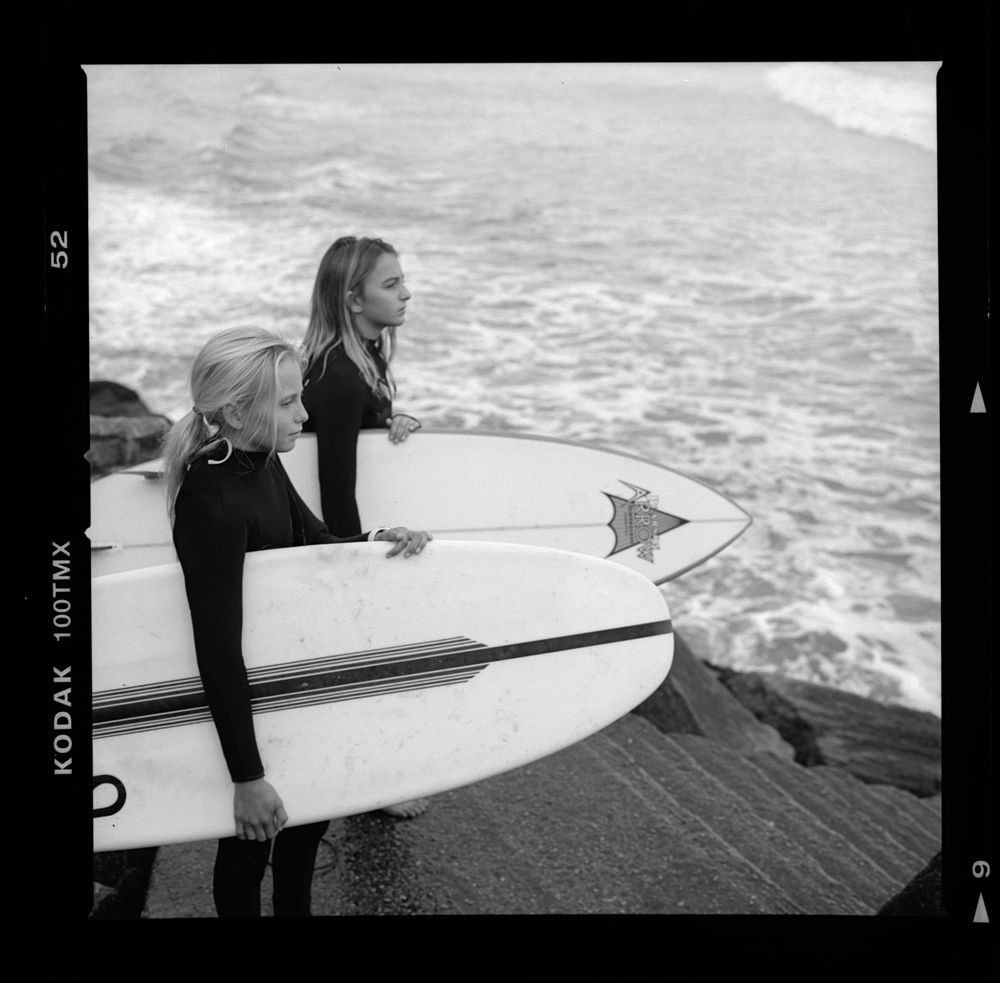 editorial portrait of two young surfers looking towards ocean in natural light along the central coast california , san luis obispo