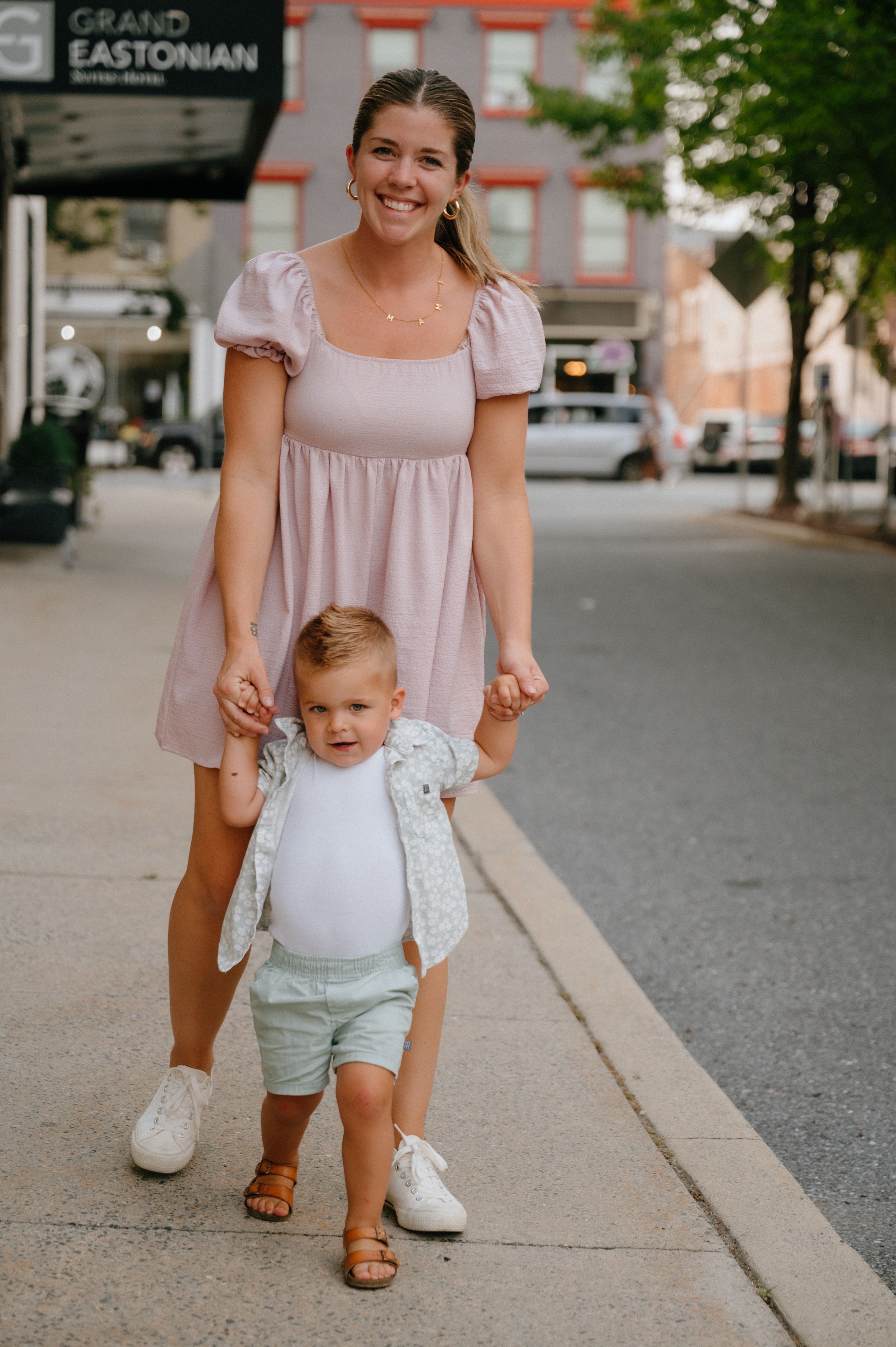 A joyful stroll on a city sidewalk near the Grand Eastonian building.