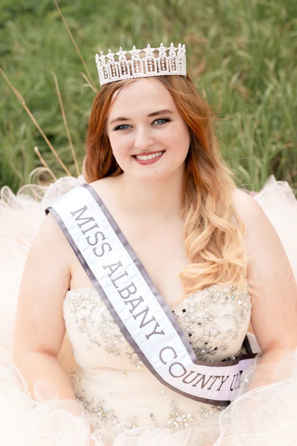 A pageant winner wearing a crystal crown and sash.