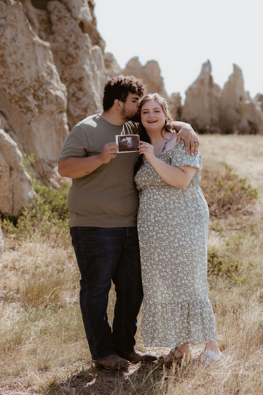 Romantic engagement photoshoot in a desert landscape with rock formations.