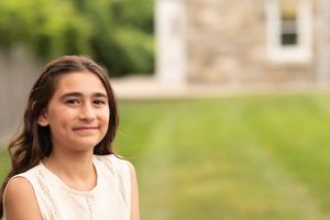 Four connected portrait photos show someone smiling and posing outdoors with a natural background.