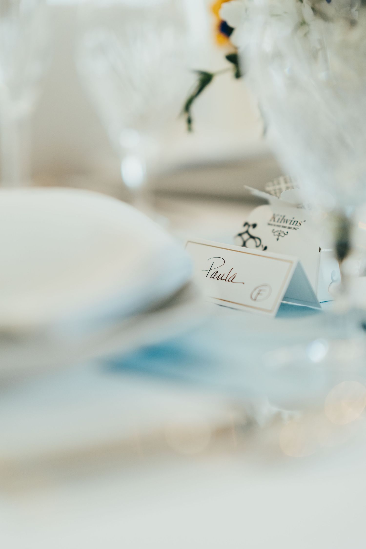 Elegant place card for wedding seating arrangement with floral decor.