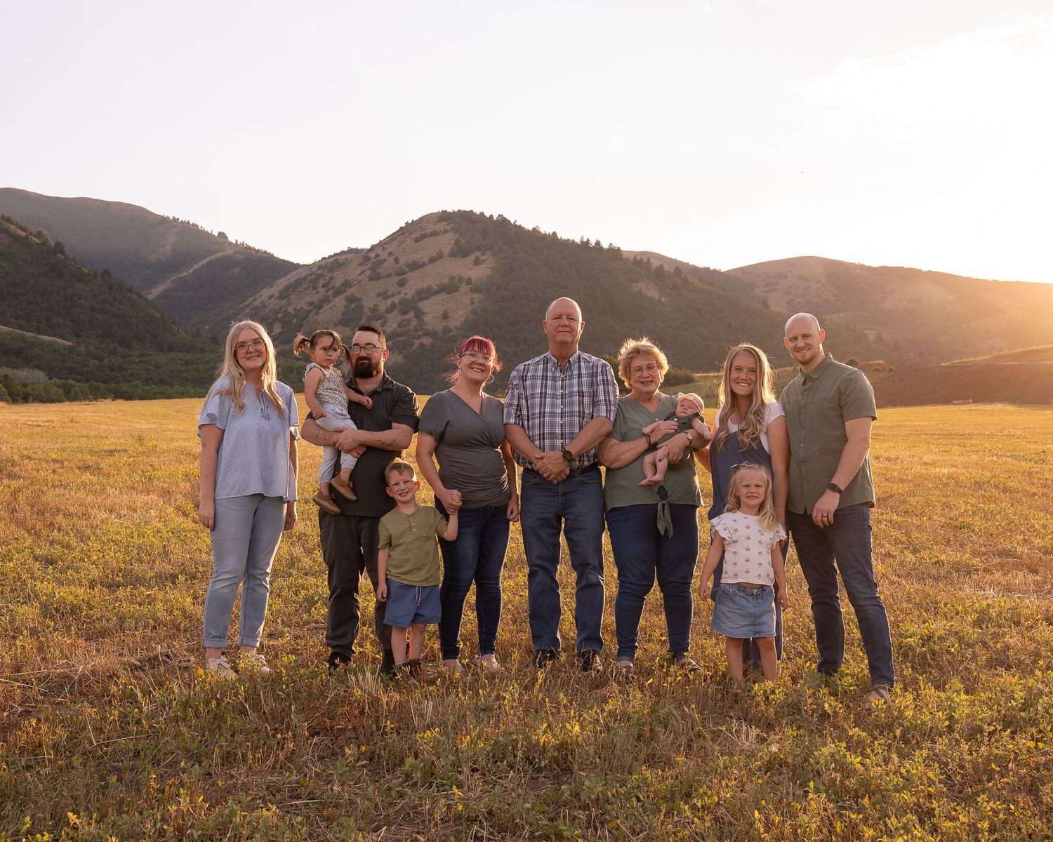 A beautiful family of four embracing in the forest in Tony's grove in logan canyon during a fall family session with fall colors.