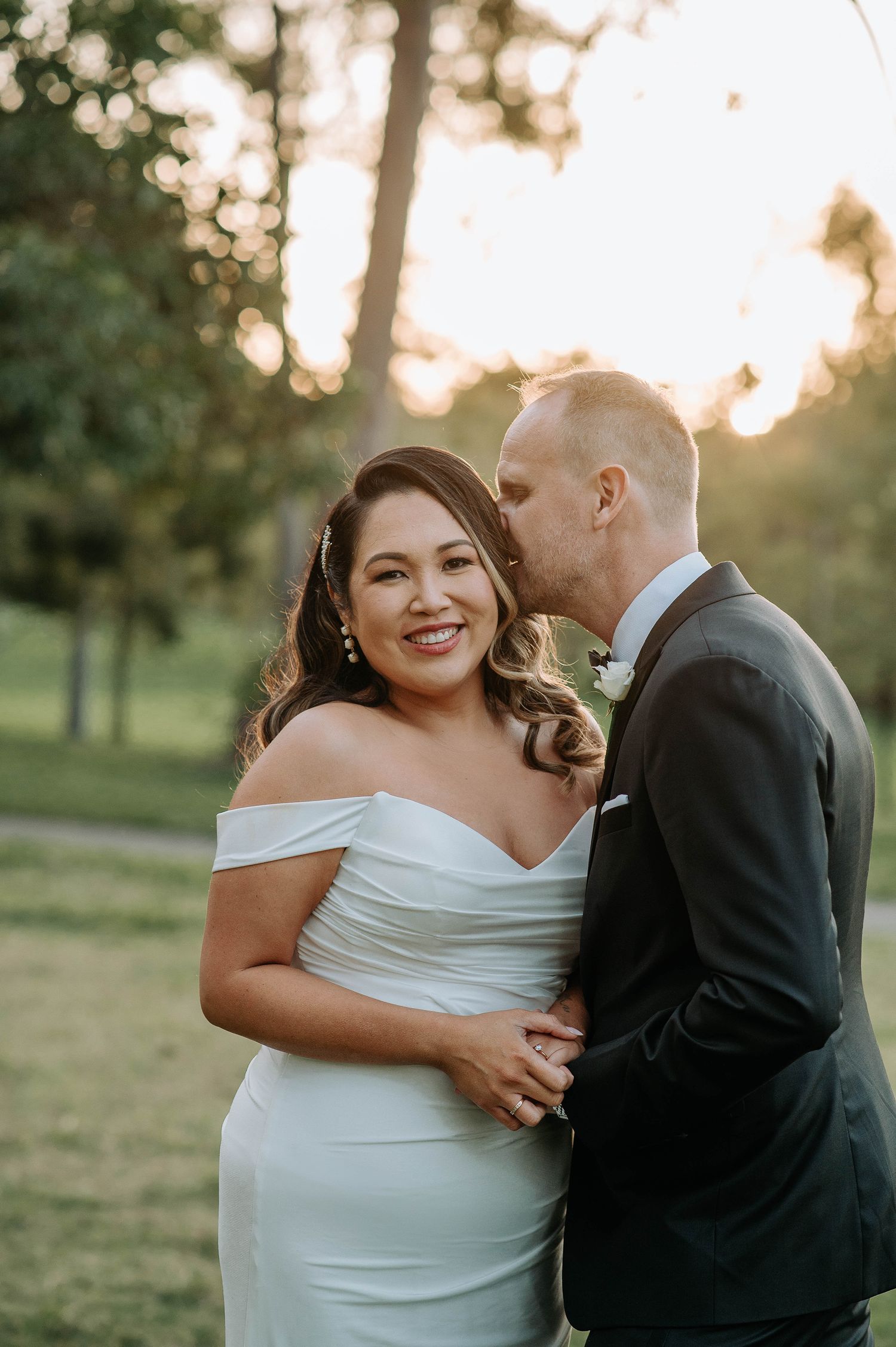 Joyful wedding couple sharing an intimate moment during golden hour photography session.