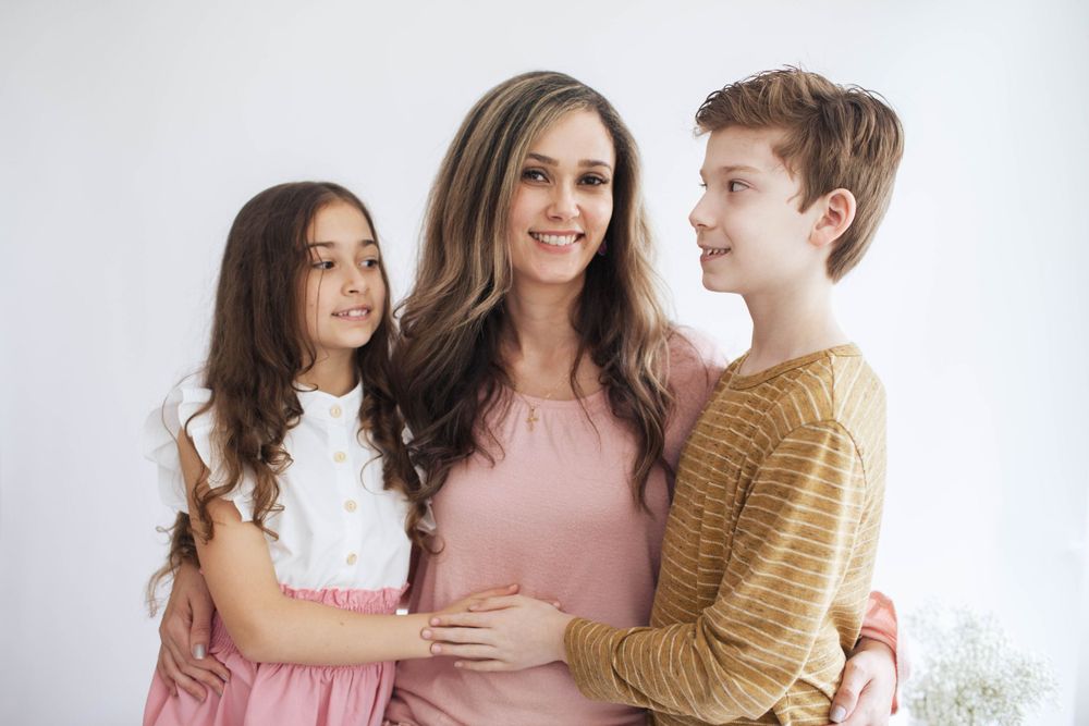 everett family photography: a mother poses with her two kids at an indoor family photo session