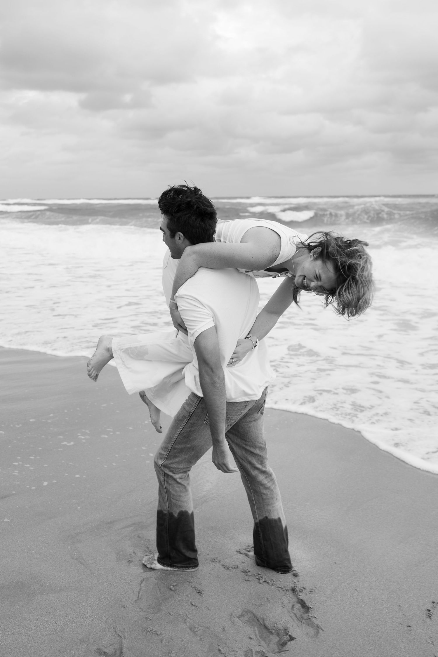 Sunrise engagement session on the beach at Coral Cove Park in Jupiter, Florida captured by Lindsay McDow Photography. Water, rocks, couple