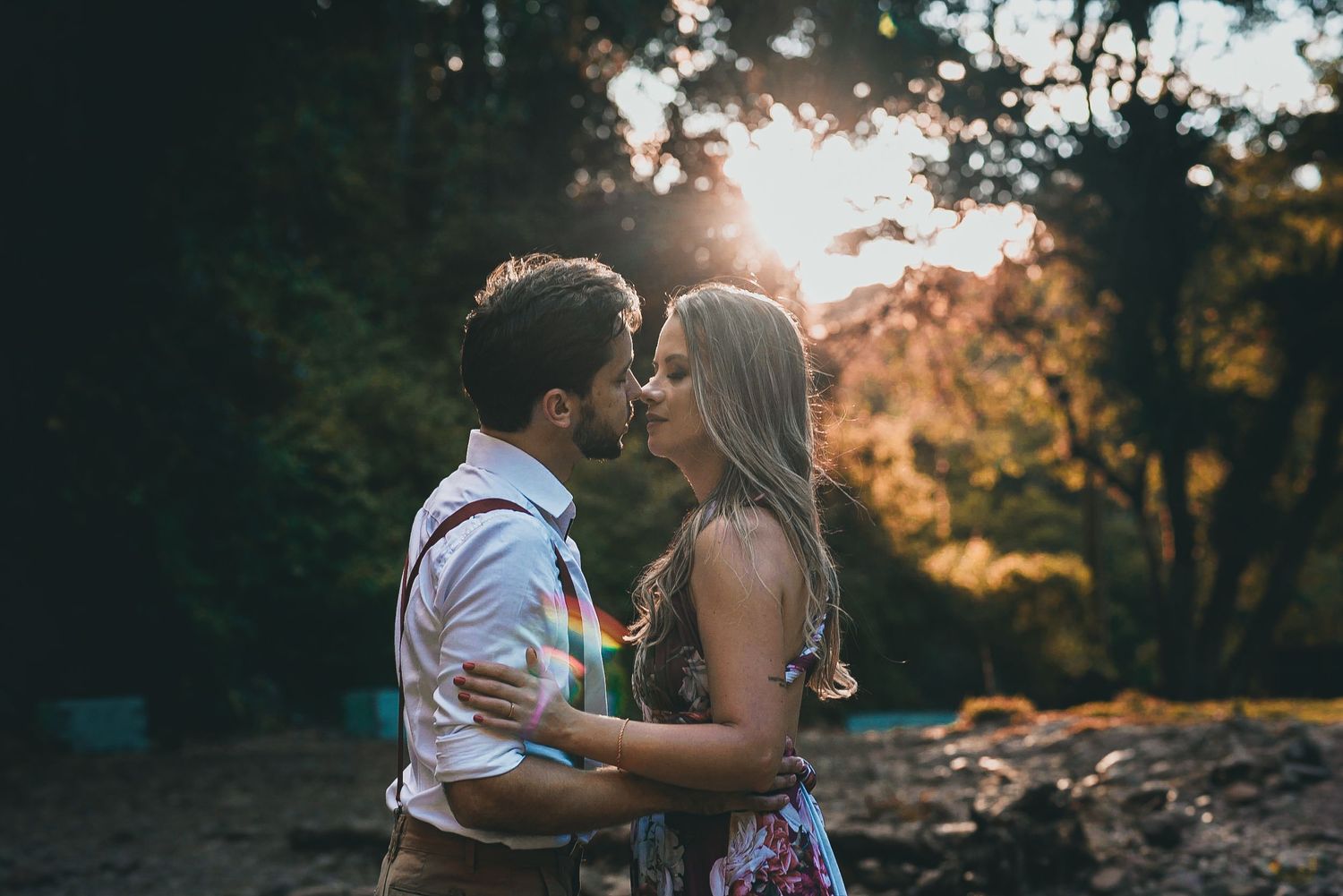 A romantic moment captured between a couple during a sunset photoshoot in the woods.