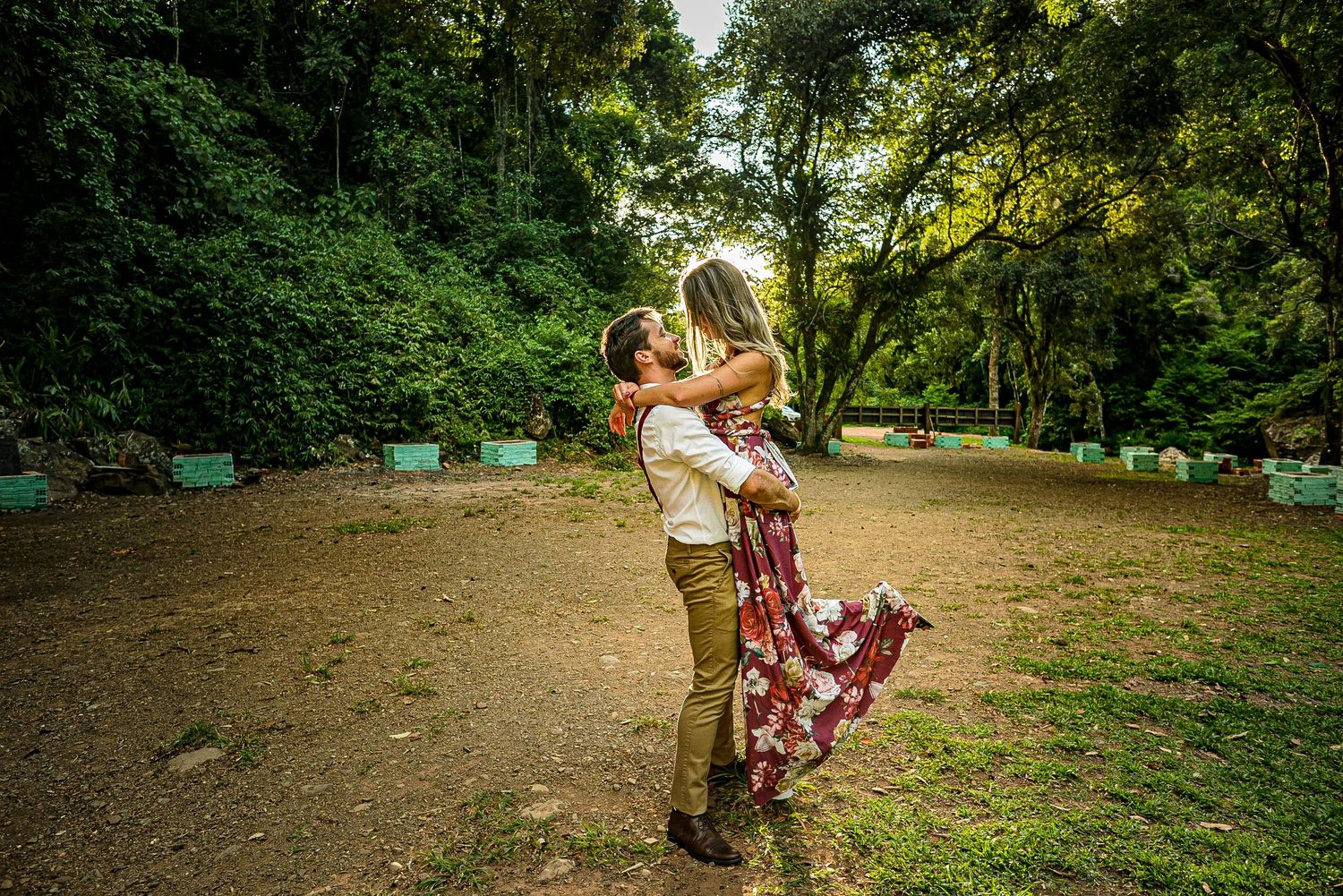 A romantic embrace in a lush forest setting surrounded by greenery.