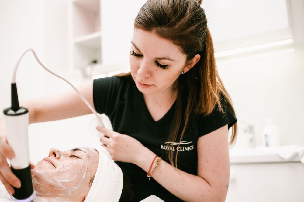 Esthetician performing specialized facial treatment steps in clinical setting.