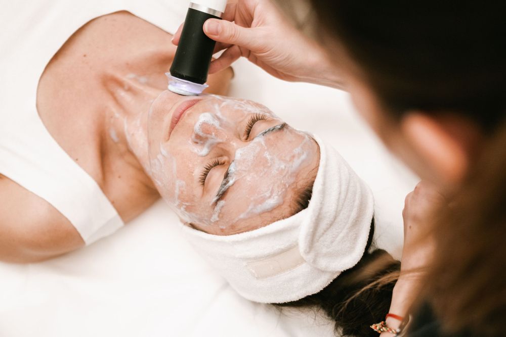 Spa technician applying facial treatment products during professional skincare service.
