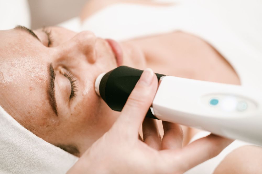 Professional skincare treatment being administered with modern beauty equipment.