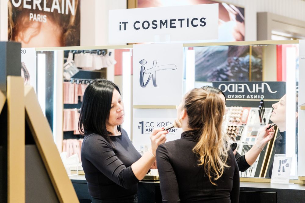 Cosmetics retail environment showing IT Cosmetics and luxury brand displays.