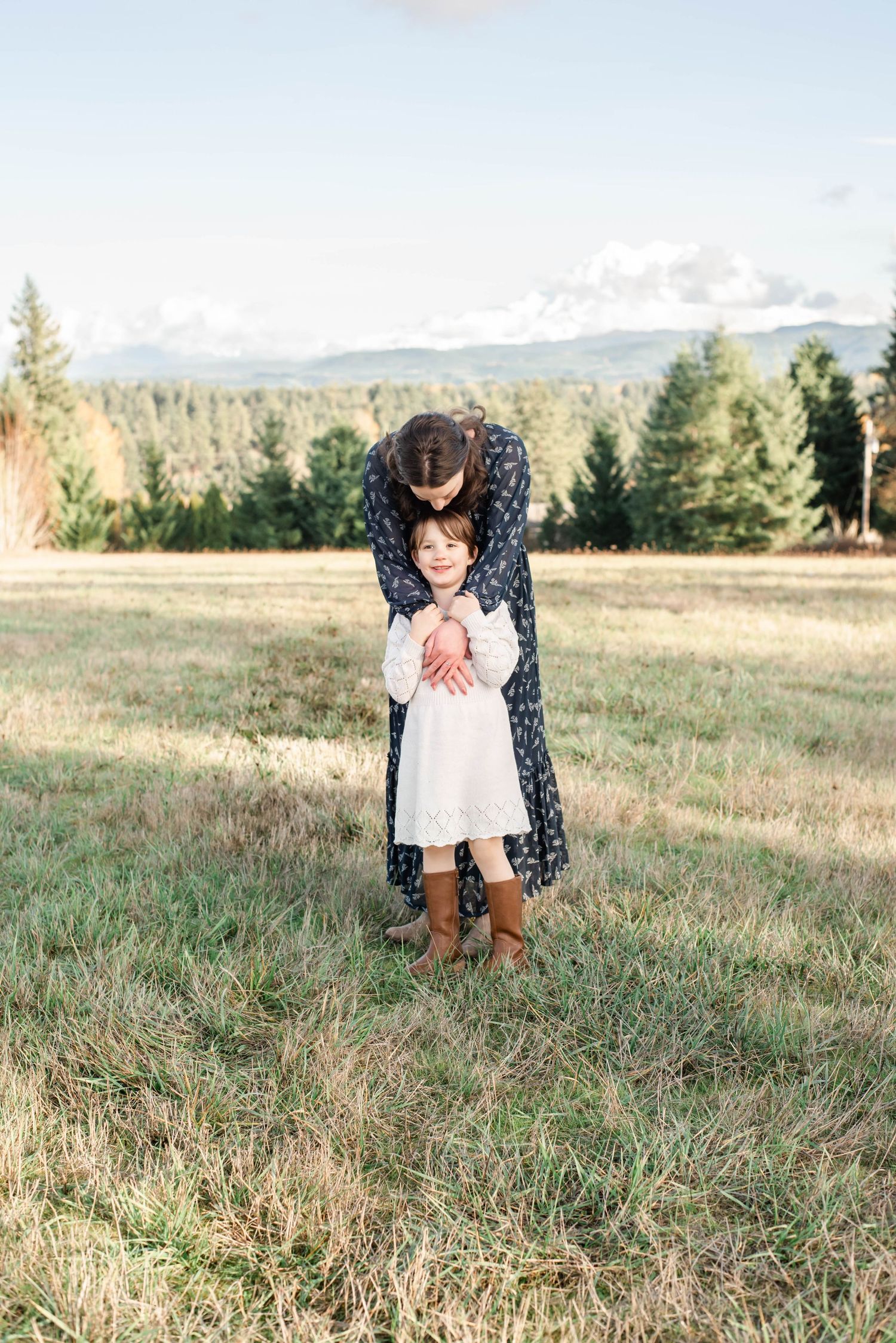 Playful interaction between parent and child in mountain field setting.