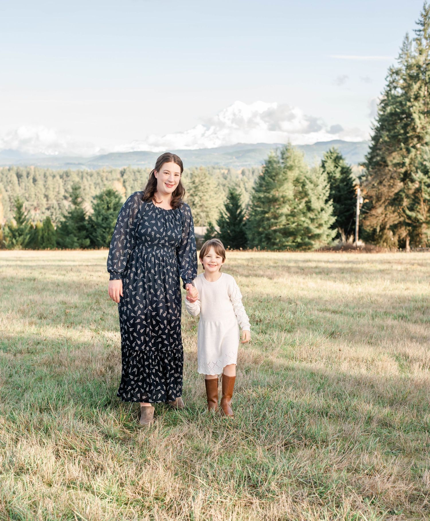 A joyful portrait session in a mountainside meadow at sunset with a mother and daughter.