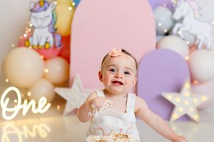 A colorful first birthday party setup with pastel decorations, cake, and festive party elements.