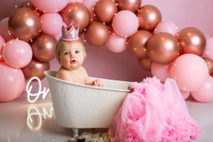 Bath tub portrait setup with pink tulle and rose gold balloon arch.