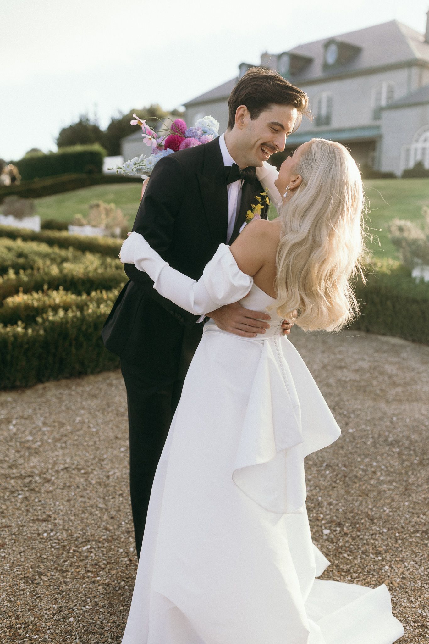 Campbell Point House Melbourne bride and groom kissing in the garden of hedges