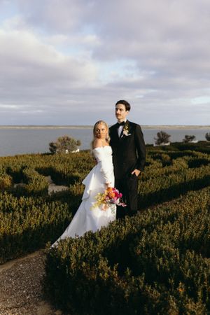 Bride and groom in hedged garden at Campbell Point House in Melbourne smiling in full evening sun