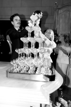Campbell Point House Melbourne bride and groom champagne tower laughing as they pour champagne