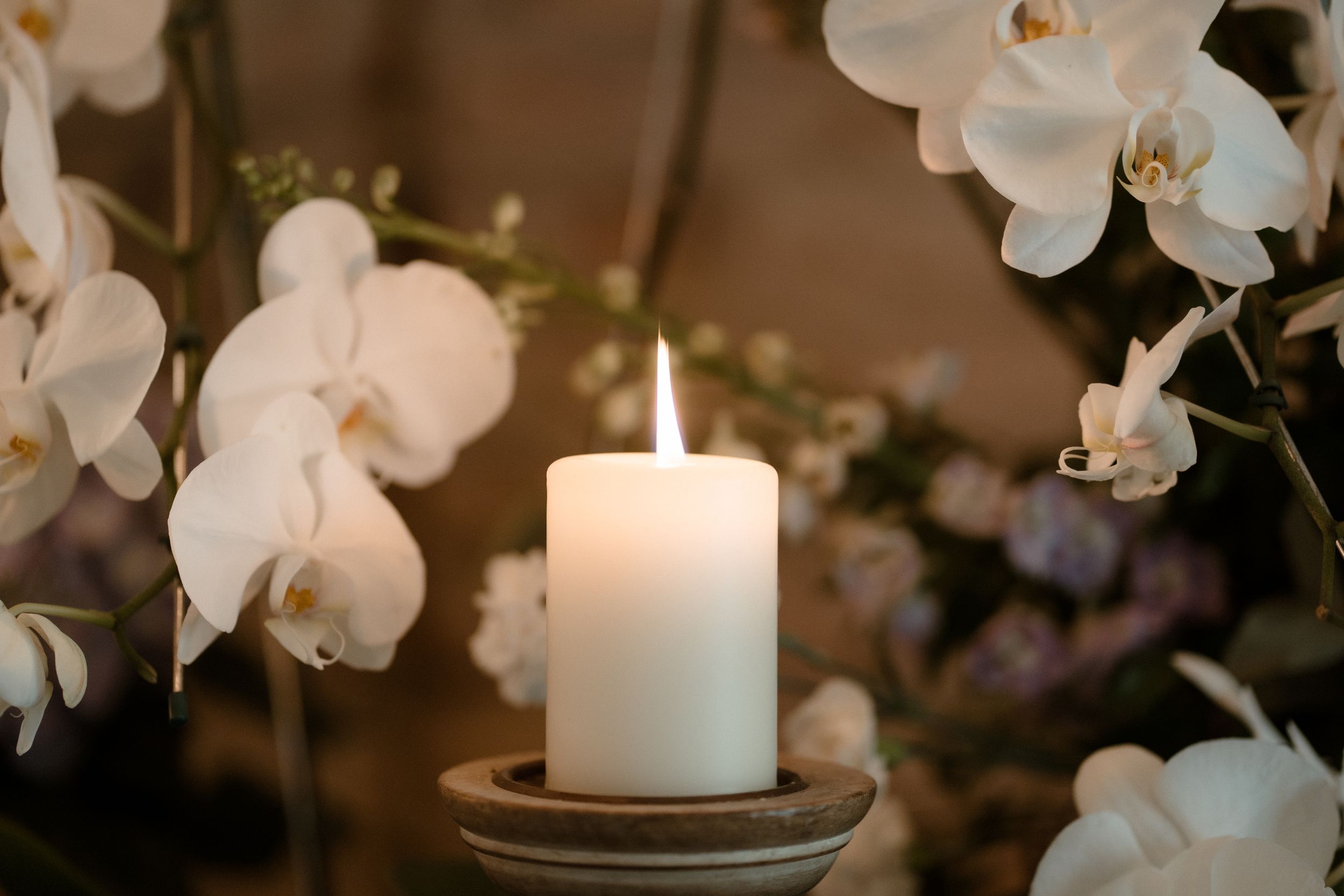 White orchids and lit candles creating an intimate wedding atmosphere.