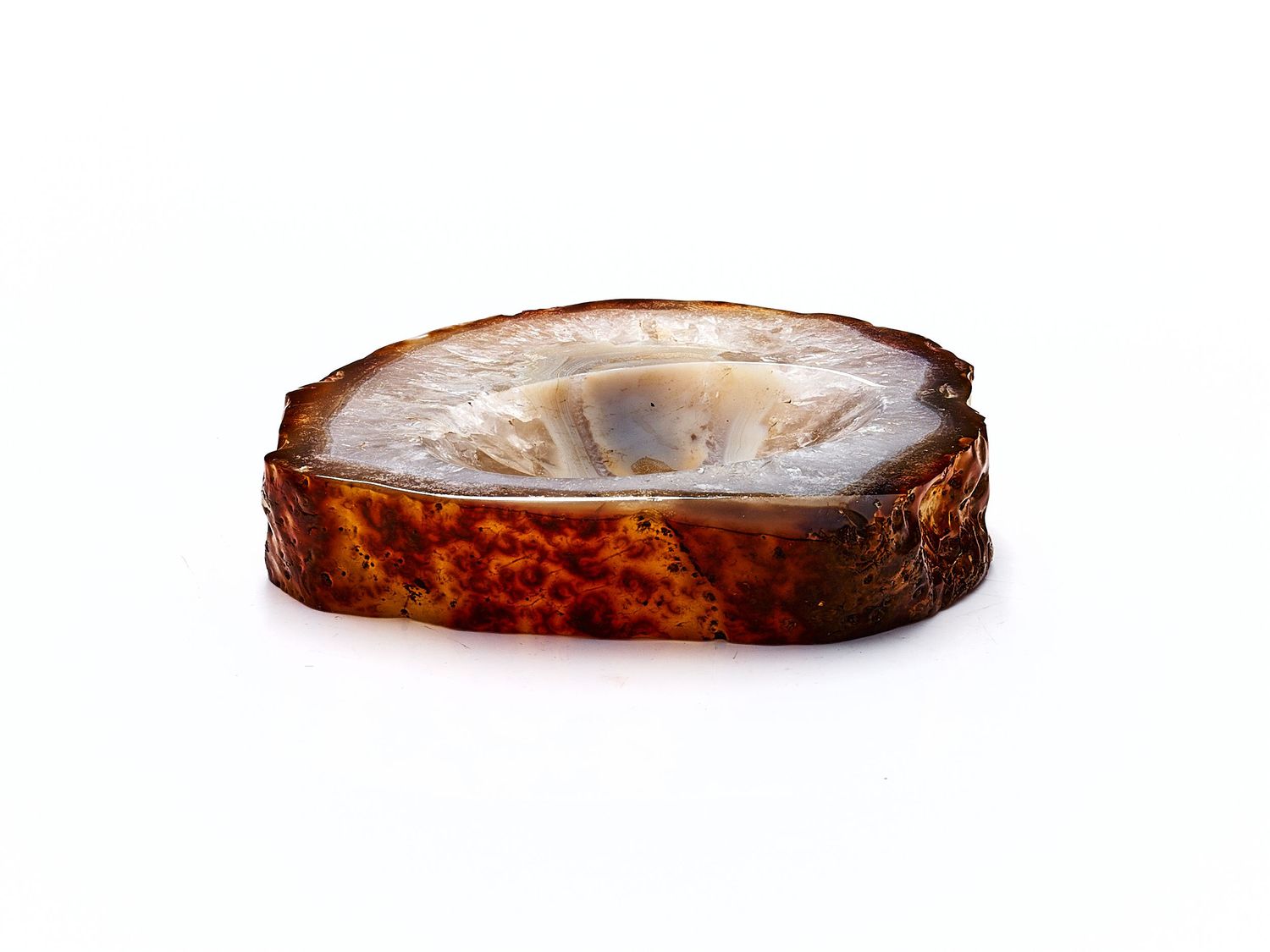 Cross-section slice of polished agate stone with rich brown outer edge and translucent white center.