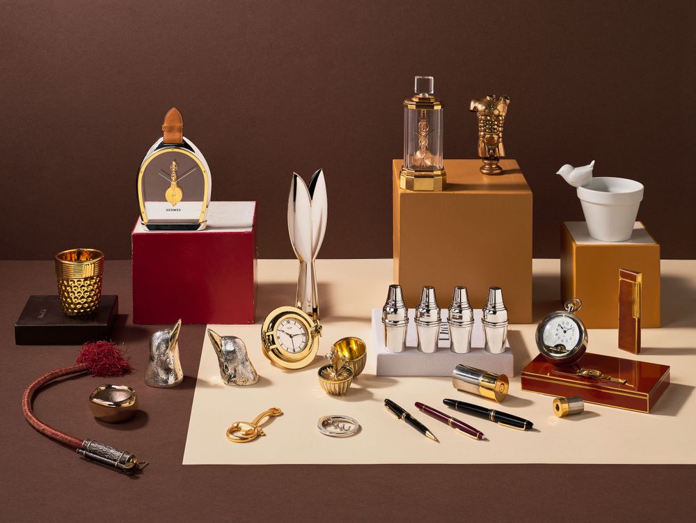 Collection of vintage and modern barware accessories displayed on wooden shelf.