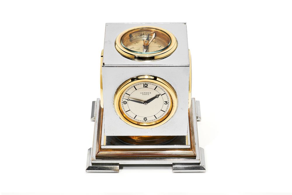 Silver and gold desk clocks displayed in a row against white background.