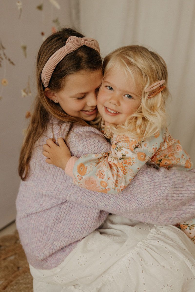 Intimate lifestyle portrait of mother and child sharing joyful moment with glitter confetti.