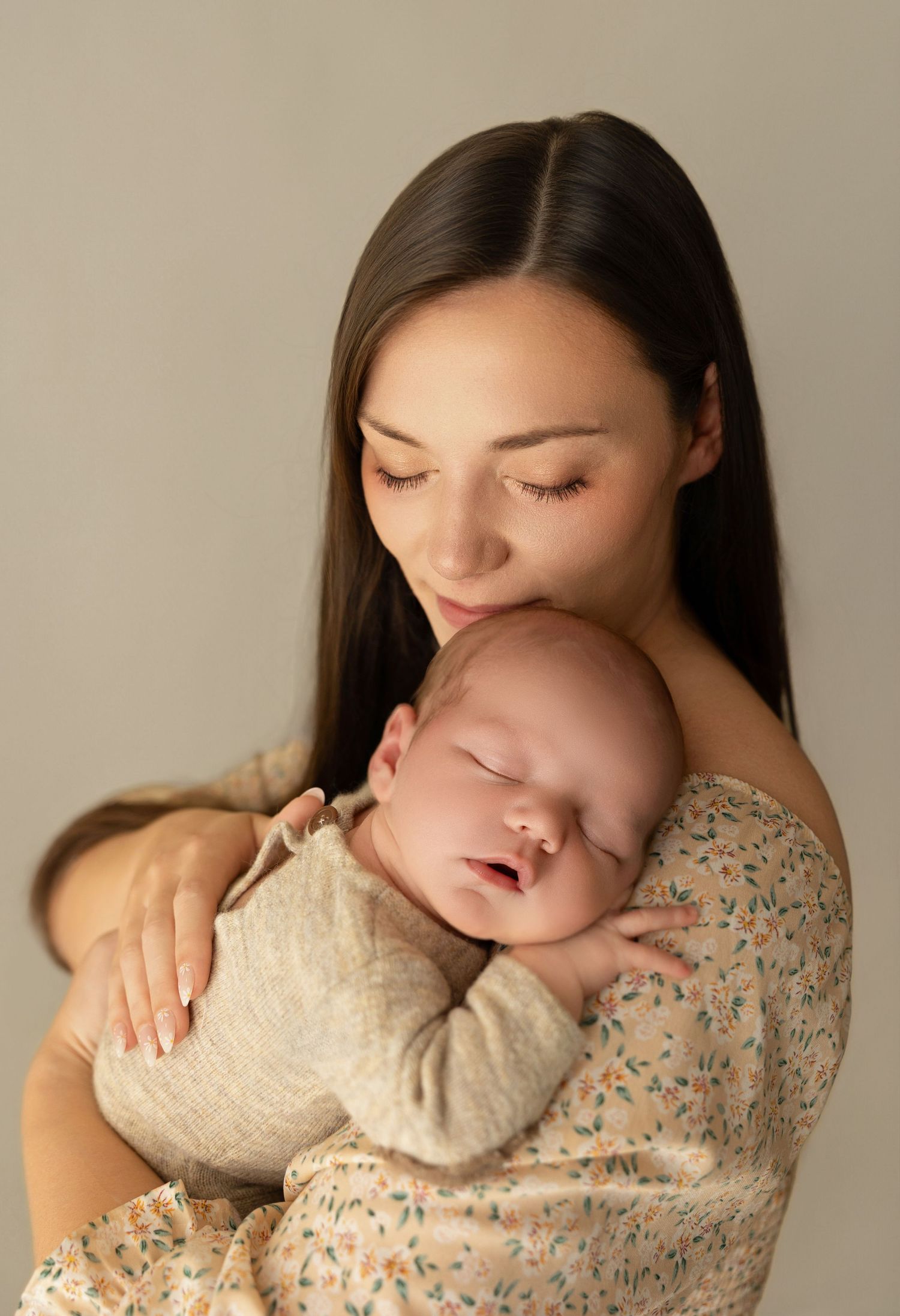 A tender sequence of parent and baby bonding moments, with gentle kisses and cuddles against a neutral backdrop.