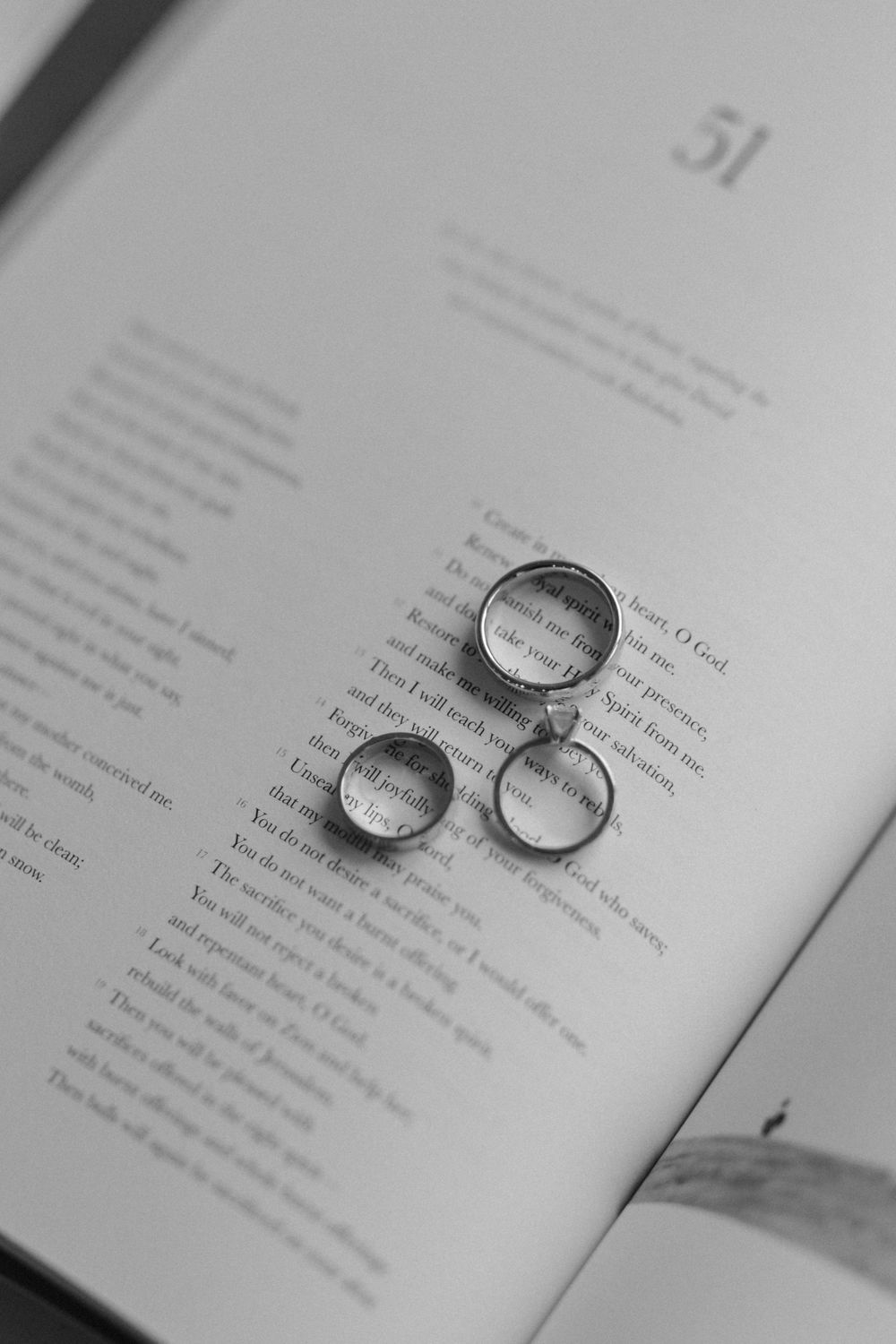Three wedding rings arranged artistically on an open book page.