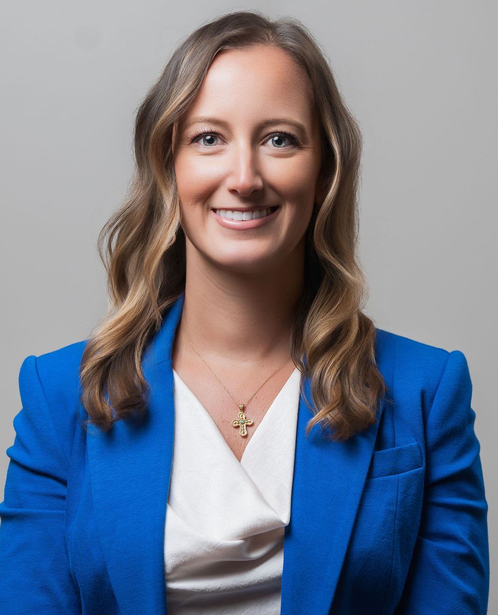Professional headshots of someone in a bright blue blazer and white top against a neutral background.