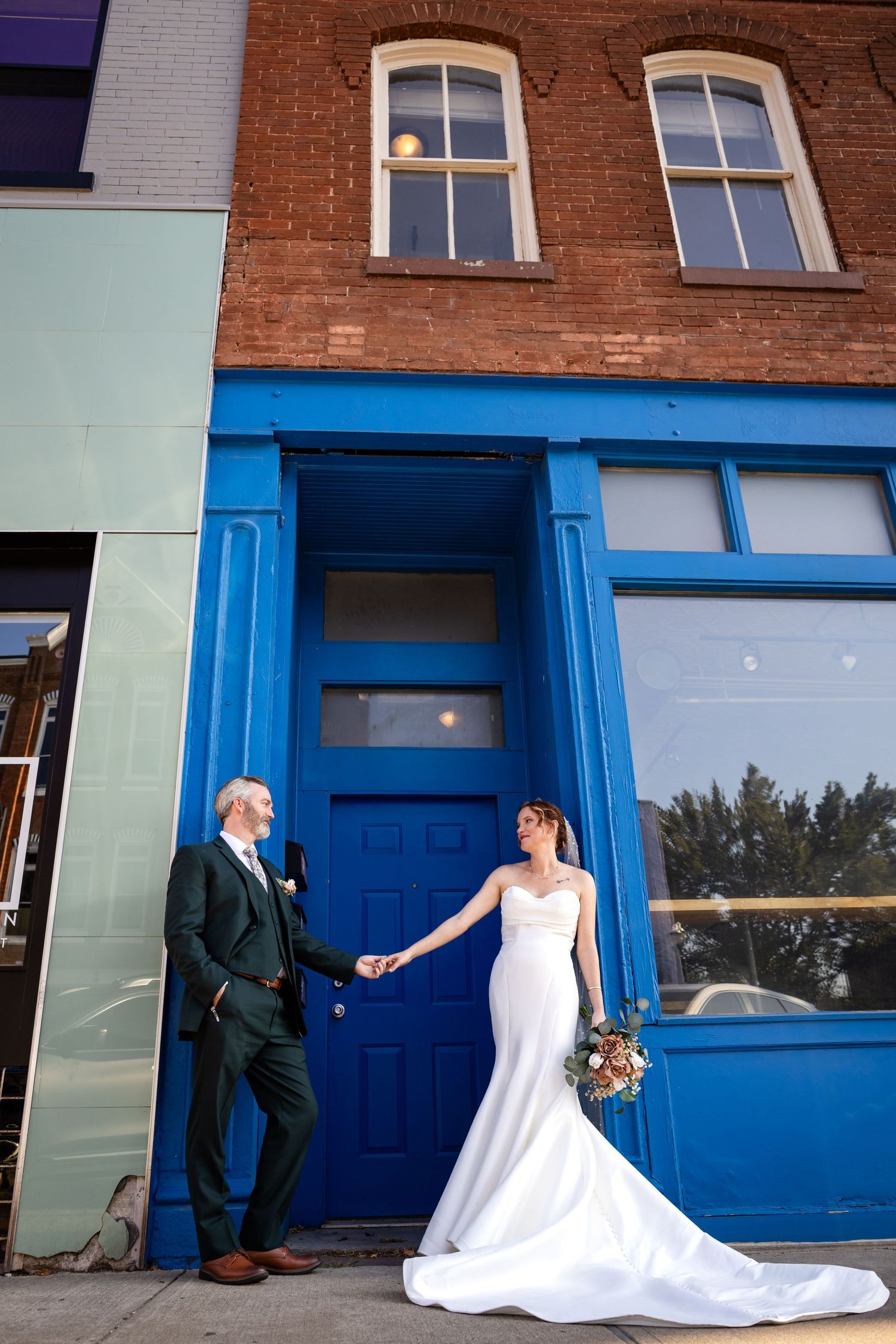 Bride and groom in front of a blue storefront door at their Springfield, Missouri wedding